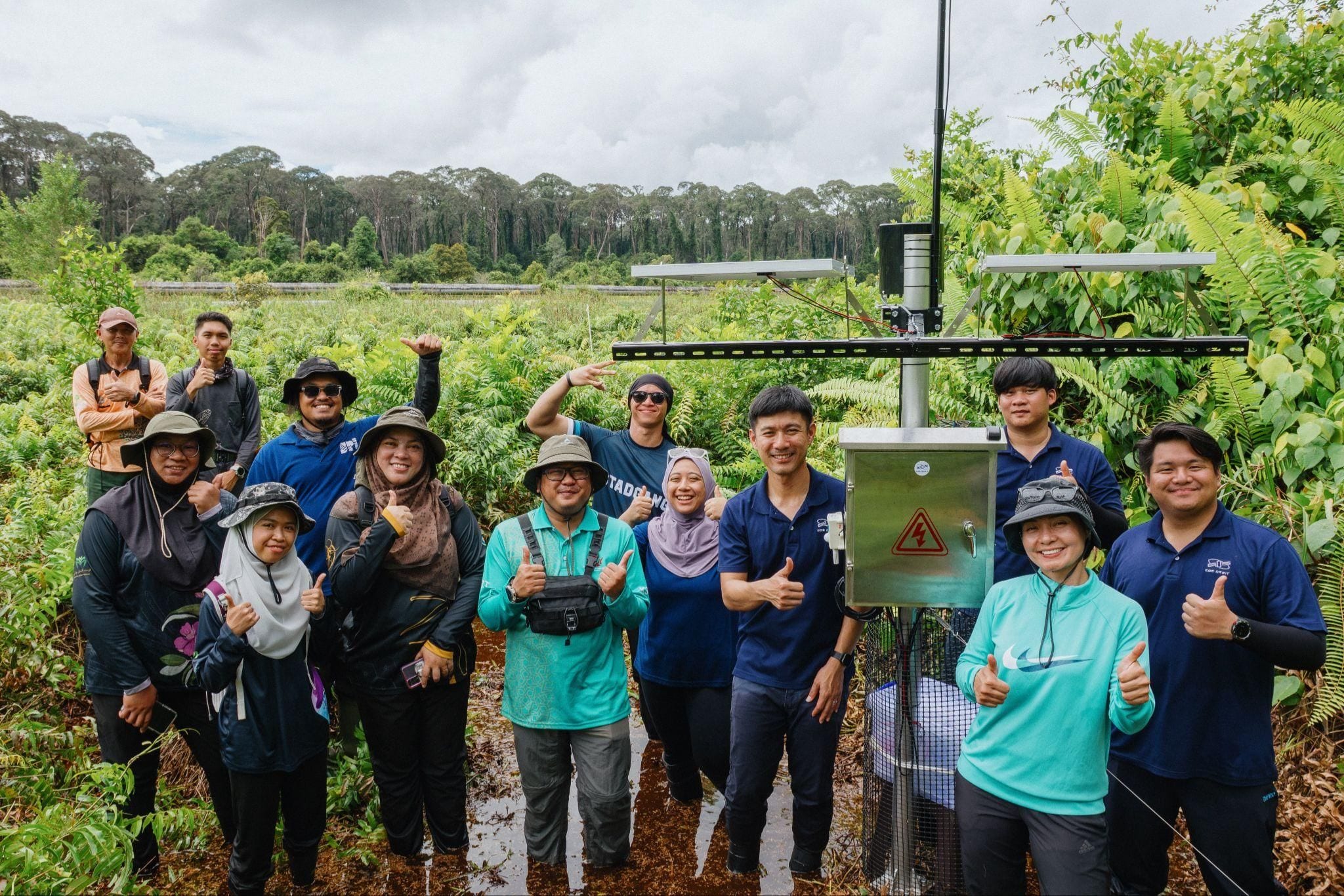 The joint EOS Orbit and SPI BN field team at a solar-powered sensor station in a Brunei peat swamp forest
