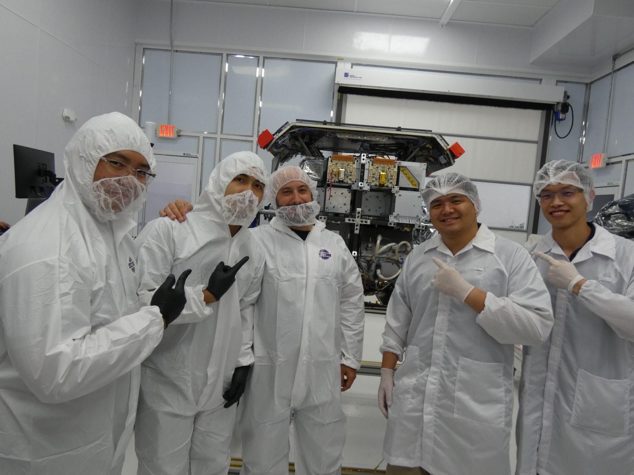 The EOS Orbit engineering team in clean-room garments beside the LOGSATS-2 deployer